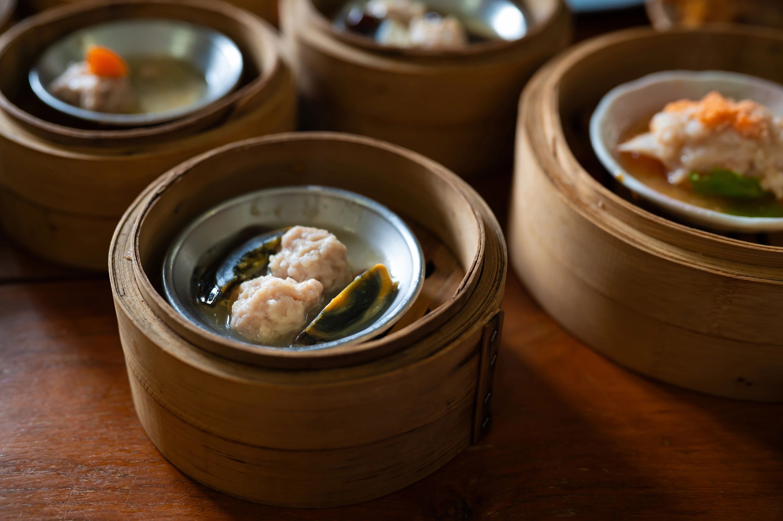 Steamed dumplings served in a bamboo basket