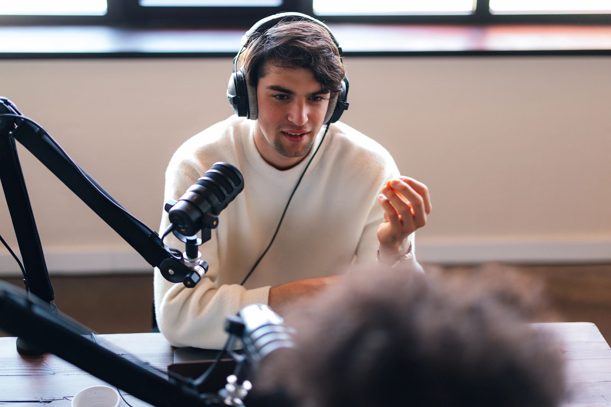 Podcast host speaking into a microphone in a recording studio